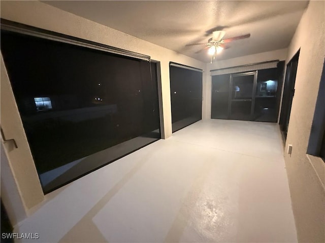 interior space featuring ceiling fan and concrete flooring