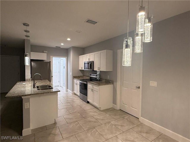 kitchen featuring visible vents, white cabinets, light stone countertops, stainless steel appliances, and a sink