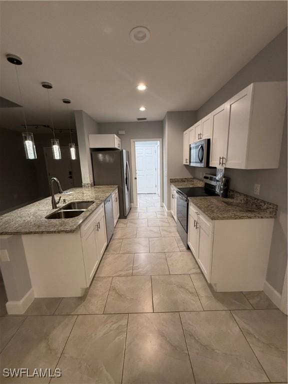 kitchen with stainless steel appliances, white cabinetry, a sink, and a peninsula