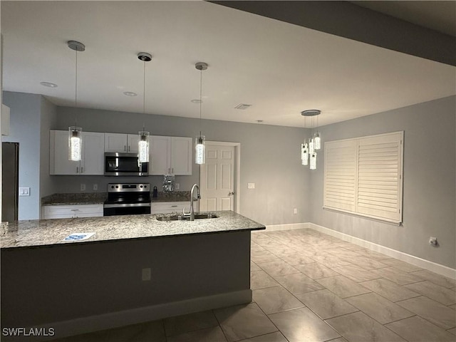 kitchen featuring baseboards, appliances with stainless steel finishes, light stone counters, decorative light fixtures, and a sink