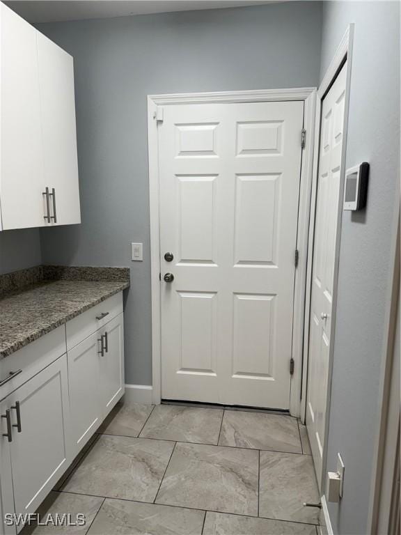 interior space with marble finish floor and baseboards