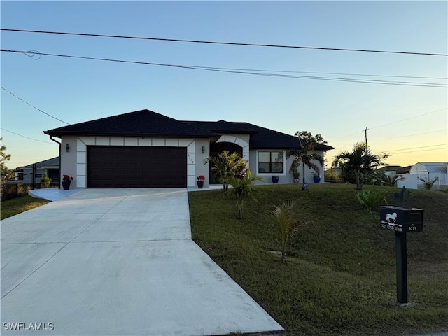 view of front of home with a lawn and a garage