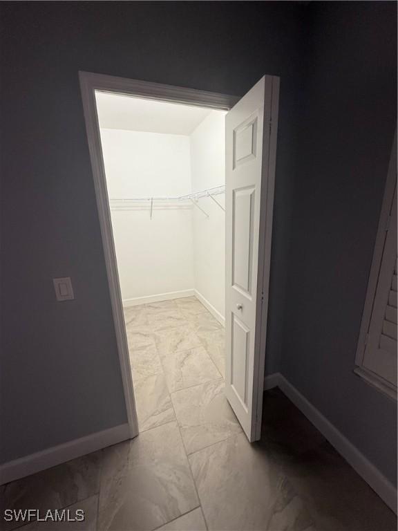 spacious closet with marble finish floor