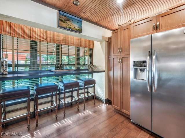 kitchen featuring dark wood-type flooring, stainless steel fridge, and wood ceiling