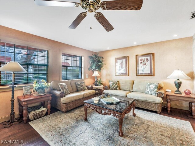 living room with dark wood-type flooring and ceiling fan