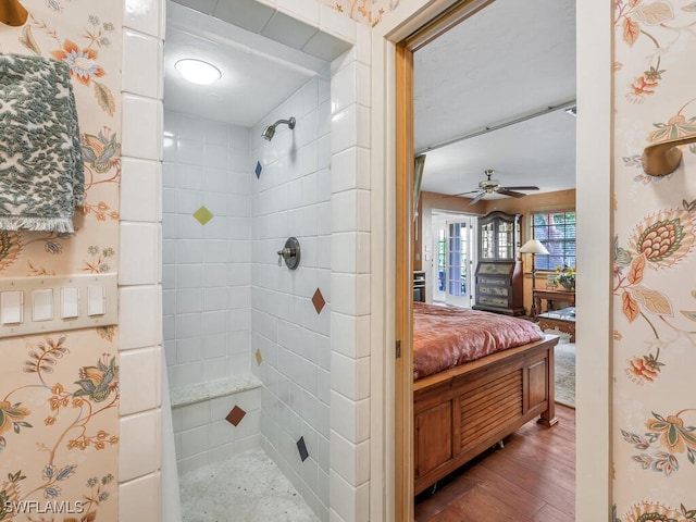 bathroom featuring ceiling fan, hardwood / wood-style floors, and a tile shower