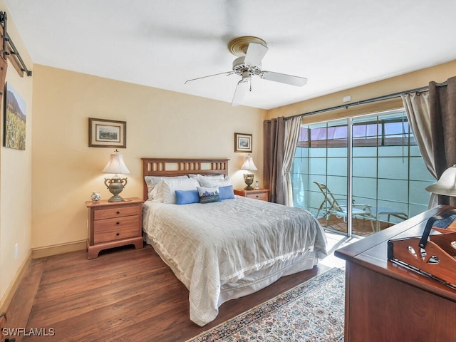 bedroom featuring access to exterior, dark hardwood / wood-style floors, a barn door, and ceiling fan