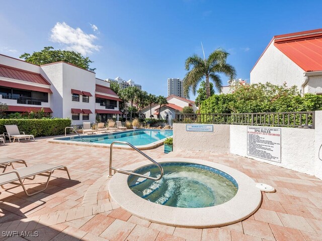 view of swimming pool with a hot tub and a patio area