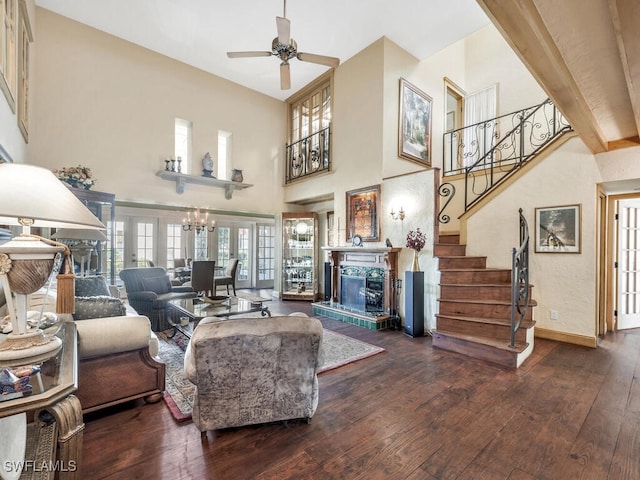 living room with hardwood / wood-style flooring, french doors, ceiling fan, and a towering ceiling