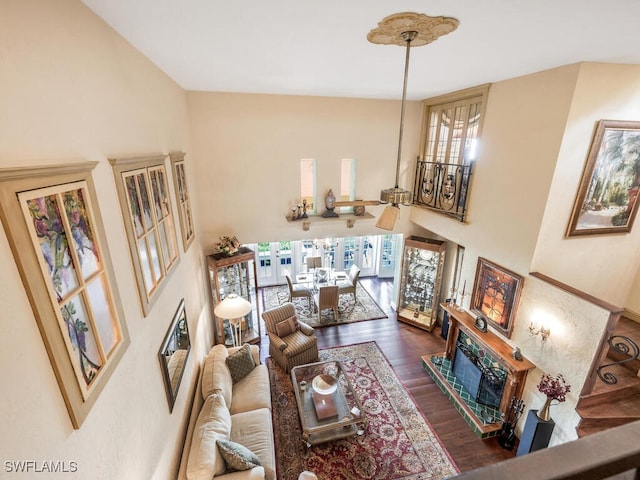 living room featuring a high ceiling, dark wood-type flooring, and ceiling fan