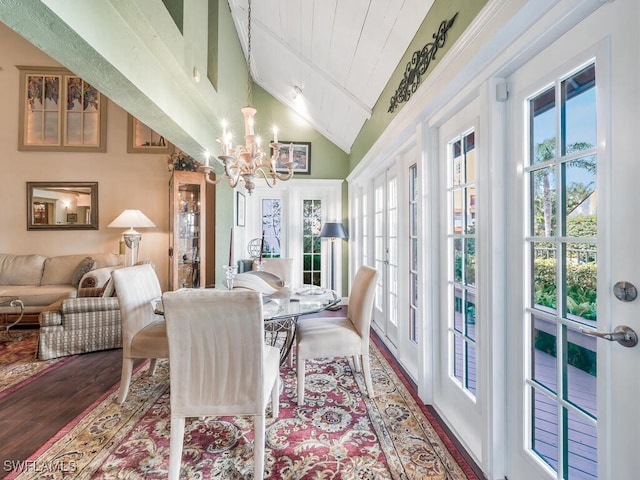 dining room with hardwood / wood-style flooring, lofted ceiling, a notable chandelier, and french doors