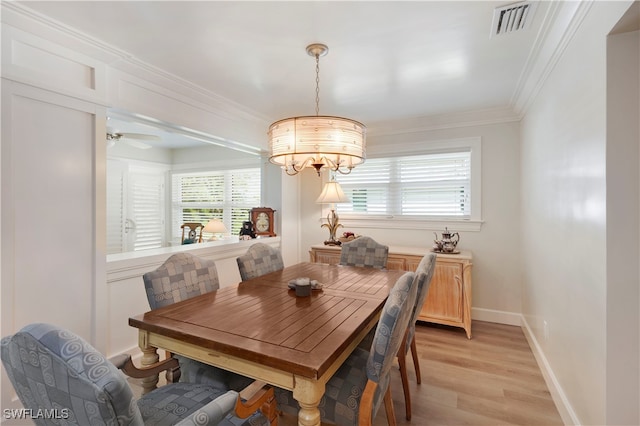 dining area featuring ceiling fan with notable chandelier, light wood-type flooring, and crown molding