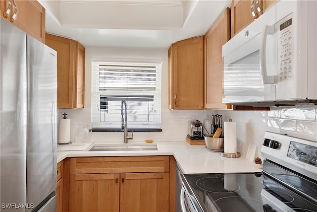 kitchen with backsplash, appliances with stainless steel finishes, and sink