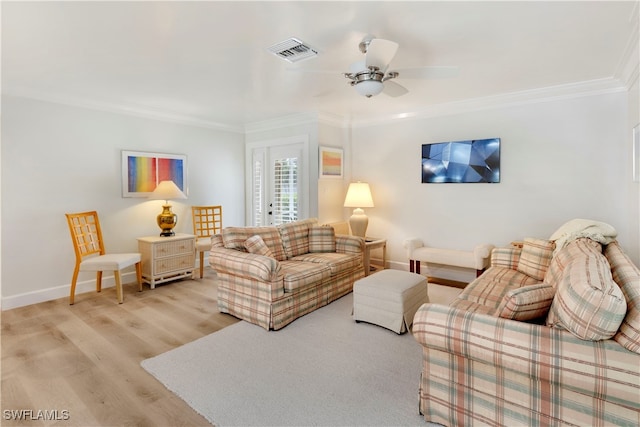 living room with ornamental molding, ceiling fan, and light hardwood / wood-style floors