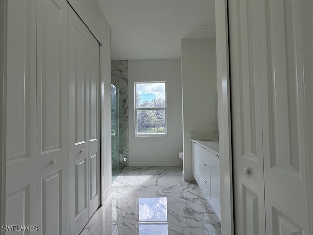 bathroom featuring toilet, a shower with shower door, and vanity