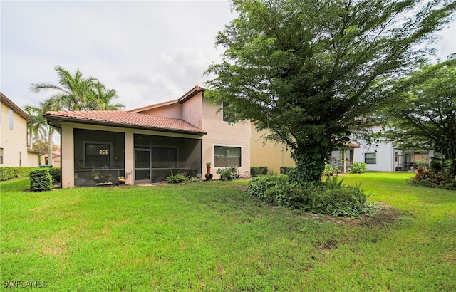 back of property with a yard and a sunroom