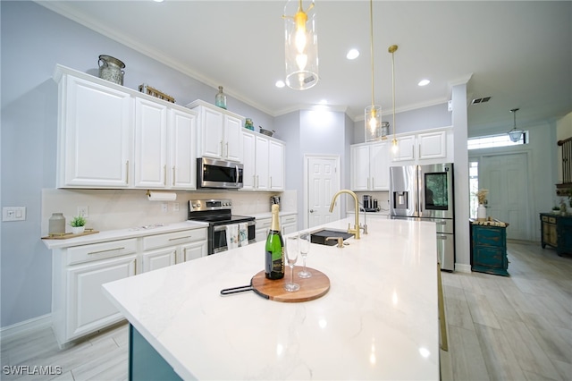 kitchen with a center island with sink, white cabinets, decorative light fixtures, and appliances with stainless steel finishes