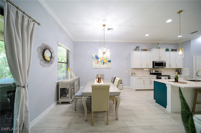 dining space with ornamental molding, sink, and an inviting chandelier