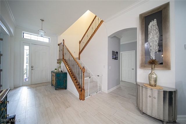 entryway featuring light wood-type flooring and ornamental molding