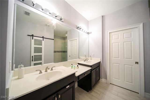 bathroom featuring hardwood / wood-style floors, vanity, and walk in shower