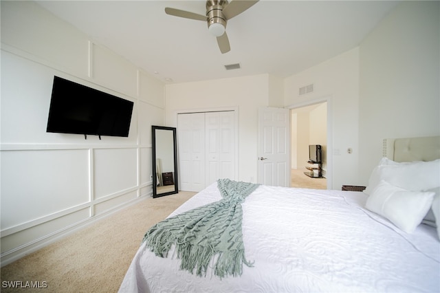 carpeted bedroom with ceiling fan and a closet