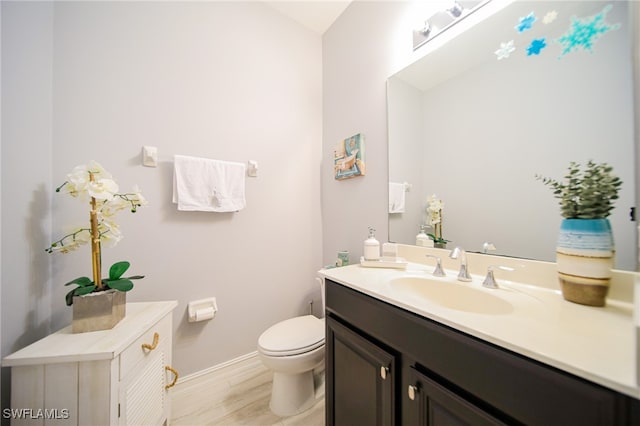 bathroom with vanity, toilet, and wood-type flooring