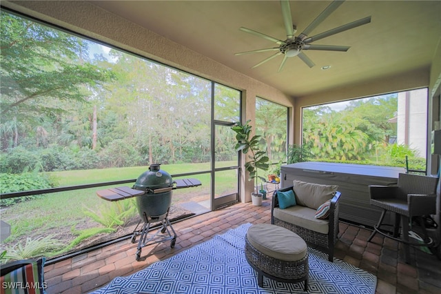 sunroom with a jacuzzi and ceiling fan