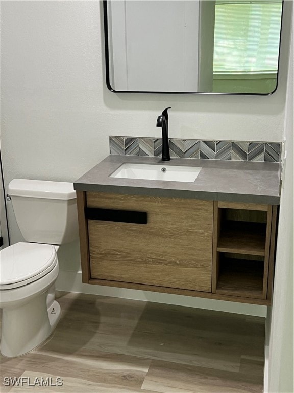 bathroom featuring vanity, hardwood / wood-style flooring, and toilet