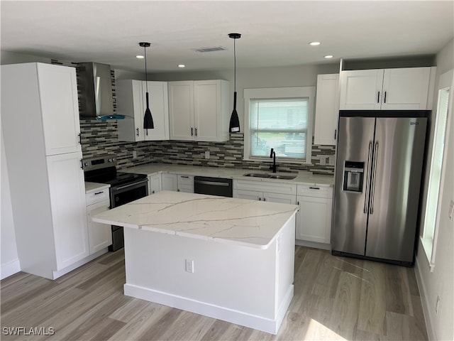 kitchen with a kitchen island, white cabinetry, sink, pendant lighting, and stainless steel appliances