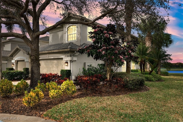 view of front facade featuring a garage and a yard