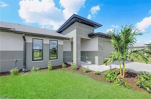 rear view of house with a lawn and a garage