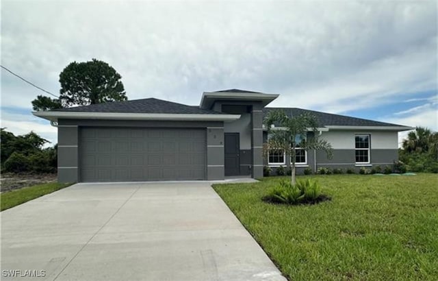646 Chambers St E, Lehigh Acres, FL 33974 - prairie-style house featuring concrete driveway, a garage, a front yard, and stucco siding