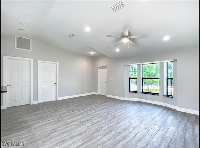 empty room featuring ceiling fan, light wood-type flooring, and lofted ceiling