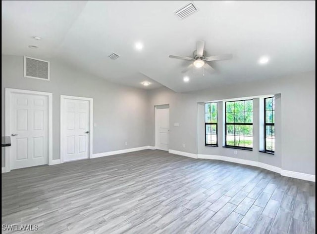 646 Chambers St E, Lehigh Acres, FL 33974 - unfurnished living room with ceiling fan, visible vents, wood finished floors, and lofted ceiling