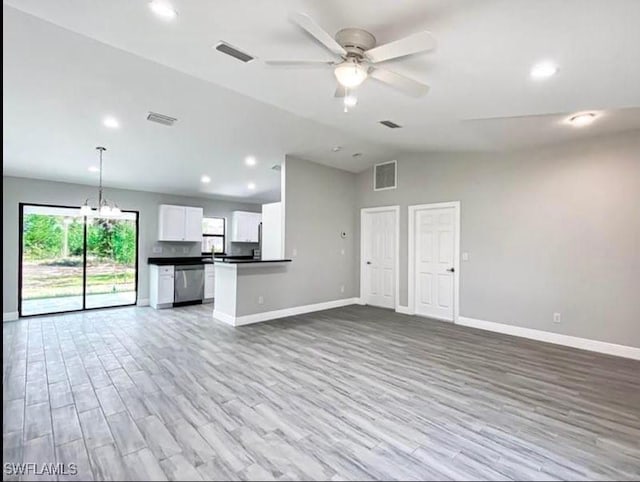 646 Chambers St E, Lehigh Acres, FL 33974 - unfurnished living room with ceiling fan with notable chandelier, wood finished floors, and visible vents