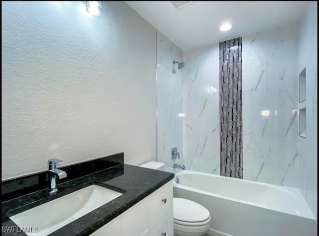 full bathroom featuring tiled shower / bath combo, toilet, and vanity