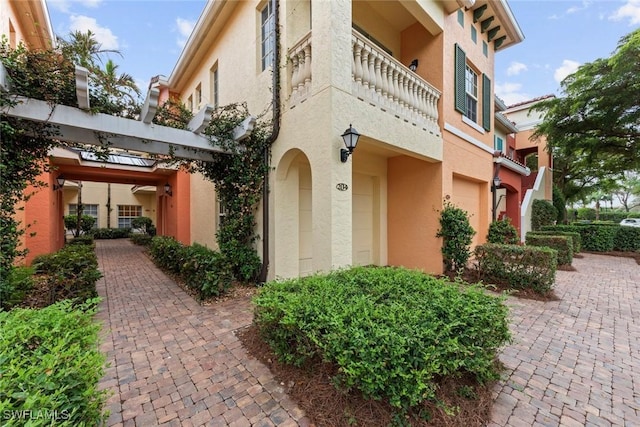 view of property exterior featuring a balcony and a garage