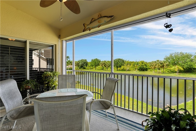 sunroom with a water view and ceiling fan