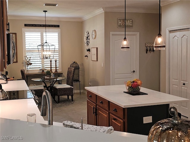 kitchen with a center island, ornamental molding, decorative light fixtures, and light tile patterned floors