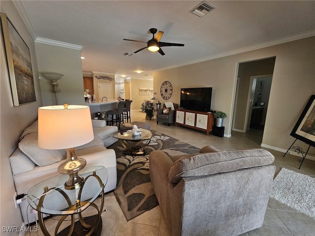 living room featuring ceiling fan, ornamental molding, and light tile patterned flooring