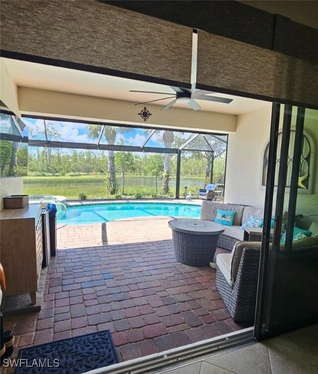 view of pool with a patio area, glass enclosure, and ceiling fan