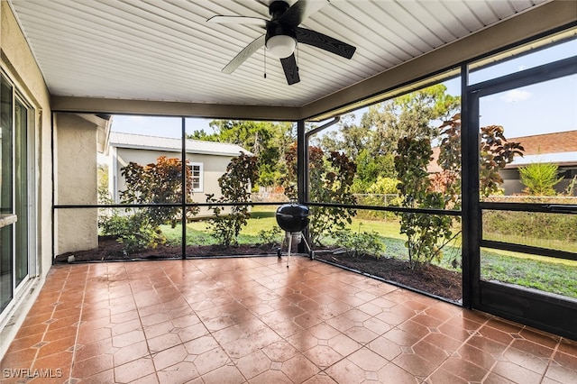 unfurnished sunroom featuring ceiling fan