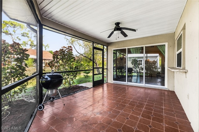 unfurnished sunroom with ceiling fan