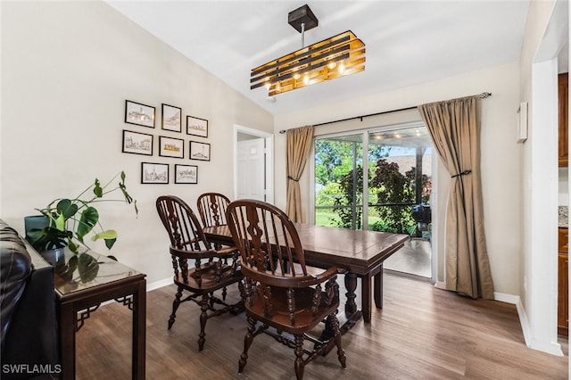 dining room featuring hardwood / wood-style flooring and vaulted ceiling