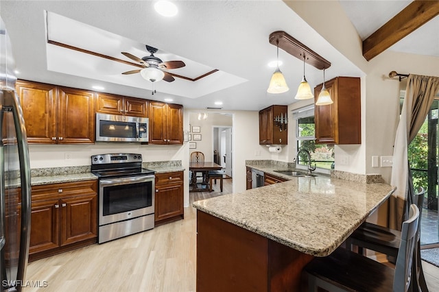 kitchen featuring sink, kitchen peninsula, stainless steel appliances, and a wealth of natural light