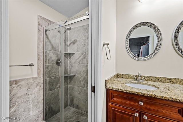 bathroom featuring vanity and a shower with door