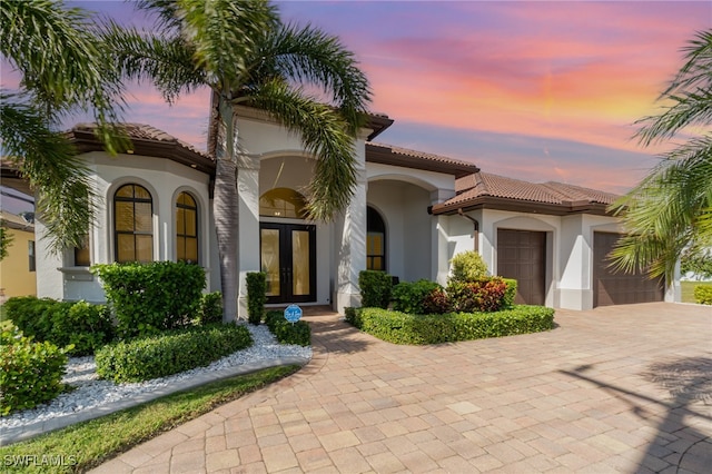 mediterranean / spanish home featuring french doors and a garage