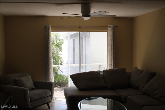 tiled living room featuring ceiling fan and a textured ceiling