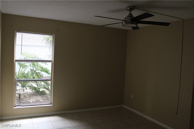 spare room with a textured ceiling, tile patterned flooring, and ceiling fan