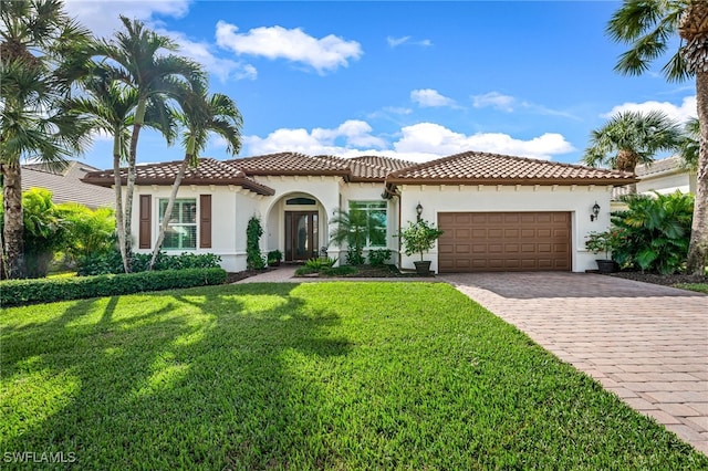 mediterranean / spanish-style house featuring a front lawn and a garage